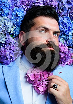 Vogue flower bow-tie. Man in blue suit. Bearded man and flower beard. Spring necktie. Elegant business man. Classical