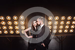 Vogue and sensual concept. Elegant celeb couple posing on the stage near lamp photo