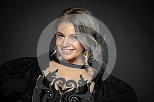 Vogue style close-up portrait of beautiful woman with curly blond hair on black background