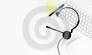 VOIP headset, pen and paper note on laptop computer keyboard. Communication support for callcenter and customer service Helpdesk.