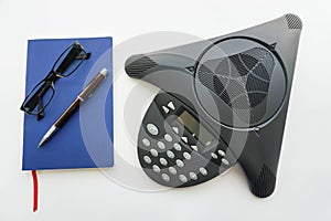 Voip IP conference phone with notebook and eyeglasses for taking minute of meeting in office