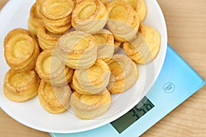 A vol-au-vent dish lies on the blue scales. Calorie counting concept, figure tracking