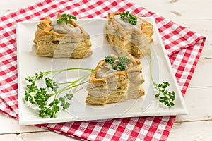 Vol-au-vents shaped like a christmas tree, filled with ragout and topped with fresh parsley
