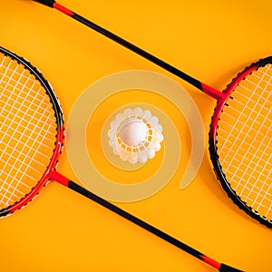 Volant and racket, badminton on yellow background. Concept excitement, resistance, competition. Pop Art Minimalism