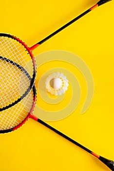 Volant and racket, badminton on yellow background. Concept of summer entertainment. Pop Art Minimalism