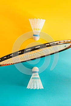 Volant and racket, badminton on yellow, blue background. Concept excitement, resistance, competition. Pop Art