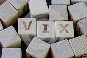 Volatility Index, known by its ticker symbol VIX concept, cube wooden block with alphabet combine the word VIX on black chalkboard