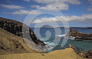 Volcanic coasts of Lanzarote, emerald Mediterranean sea and view of Fuerteventura