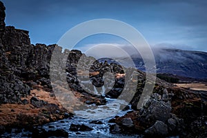 Volcanic landscape with a cascade river in Thingvellir, Iceland.