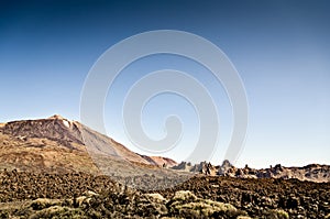 Volcanic landscape of El Teide volcano national park. Dry rock landscape with volcano mountain and deep blue sky. Pico del Teide.