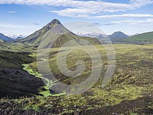 Volcanic landscape of green Storasula mountain with lush moss between Emstrur and Alftavatn camping sites on Laugavegur