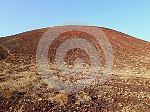 Volcanic landscape. Slope of dormant volcano in desert area under blue sky. Landscapes and extreme nature