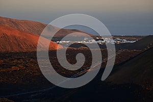 A volcanic landscape with the small town Mancha Blanca in Lanzarote in the morning light