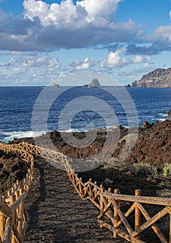 Volcanic pathway with wooden railing, with Roques de Salmor background photo