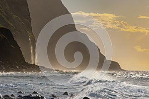 Volcanic rock cliffs Achadas da Cruz in sunlight. Sunset seascape of Madeira