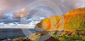 Volcanic rock cliffs Achadas da Cruz in sunlight. Sunset seascape of Madeira