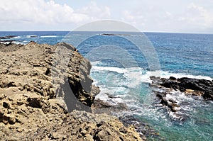 Volcanic rocks in the ocean near cliff