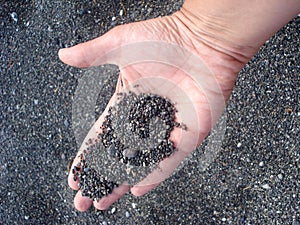 Volcanic sand in hand in Santorini island i