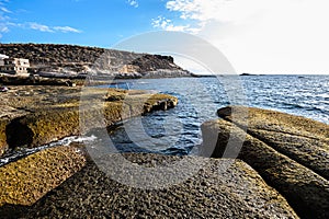 Volcanic stone beach in the city of La Caletta. Tenerife, Canary Islands, Spain