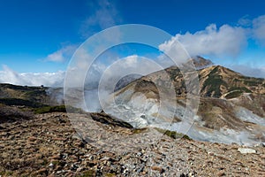 Volcanic vents with smoke and mountains with blue sky, sulphur and ash. Murodo, Japan alps