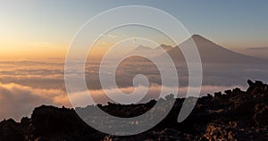 Volcano above sea of clouds at beautiful orange sunset seen from pacaya.