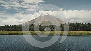 Volcano erupt at green lake shore aerial. Philippines coutryside of Legazpi town at greenery meadows