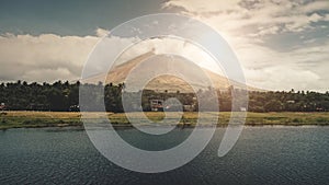 Volcano erupt at sun shine over lake shore aerial. Philippines coutryside of Legazpi town at valley photo