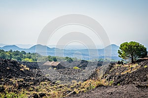 Volcano Etna view with old house and lava stones around