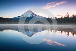 The volcano mountain Mt. Hood, in Oregon, USA. At sunset with reflection on the water of the Trillium lake. Beautiful West Coast.