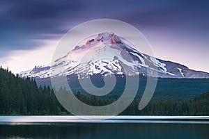 The volcano mountain Mt. Hood, in Oregon, USA. At sunset with reflection on the water of the Trillium lake. Beautiful West Coast.