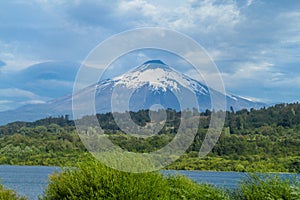 Volcano near the lake in cloudy weather