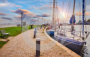 Volendam, Netherlands. Luxury yacht parked by pier on sunset photo