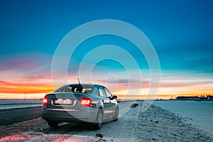 Volkswagen Polo Car Sedan Parking On A Roadside Of Country Road On A Background Of Dramatic Sunset Sky At Winter Season