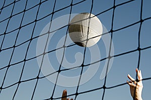 Volleyball behind net with hands