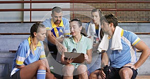 Volleyball coach assisting players on clipboard 4k