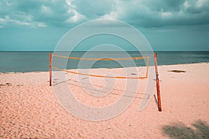 Volleyball court on an empty beach with blue cloudy sky.