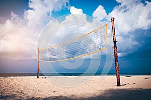 Volleyball court on an empty beach with blue cloudy sky.