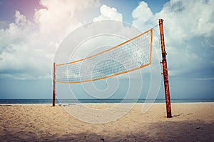Volleyball court on an empty beach with blue cloudy sky. Vintage tone