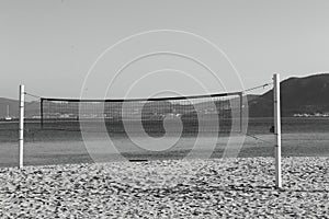A volleyball net on the beach. Black and white photography.