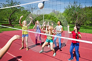 Volleyball net view on girls trying to catch ball