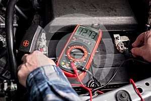 Master Mechanic tests the voltage of a truck battery using a voltage meter