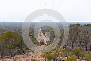 The voltage power lines running to the bush land in a rural area of New South Wales, Australia.