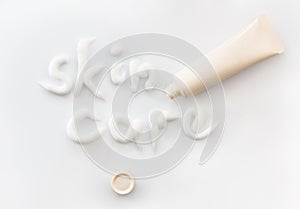 Volume inscription, made with cream on a white background with a plastic tube moisturizing face or body cream