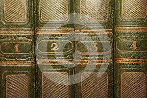 Volumes of old books with gold lettering on the cover