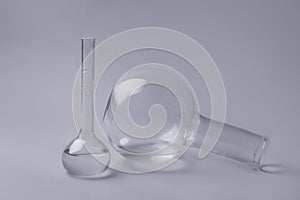 Volumetric flasks with liquid on grey background