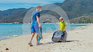 Volunteer blue face mask lazur sea sand beach. Son helps father hold black bag for pick up garbage. Problem spilled photo