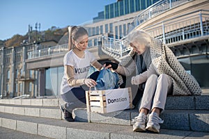 Volunteer bringing box with donation for homeless woman