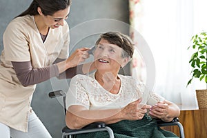 Volunteer brushing pensioner`s hair