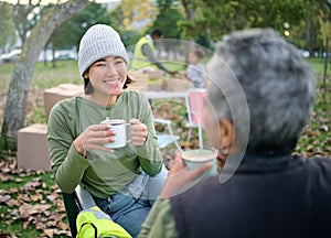 Volunteer, coffee and break by women relax after community service, cleanup and project in park, happy and bond. Charity