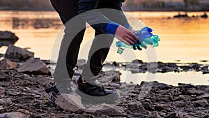 A volunteer collecting plastic on the shore. the problem of plastic pollution of ocean waters. sustainable development concept